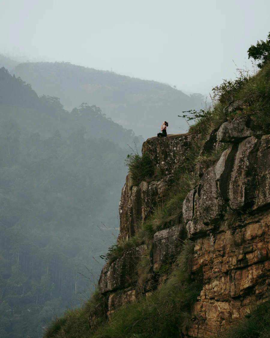 A person practicing yoga on a wooden platform overlooking a mountain lake