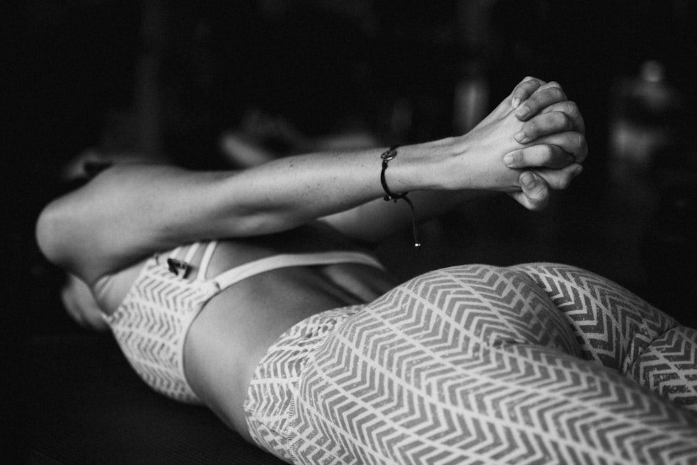 a black and white photo of a woman laying on the ground