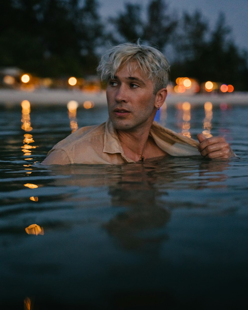 a man standing in a body of water at night