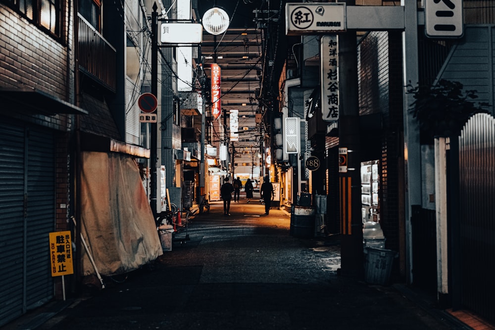 a narrow alley way with people walking down it