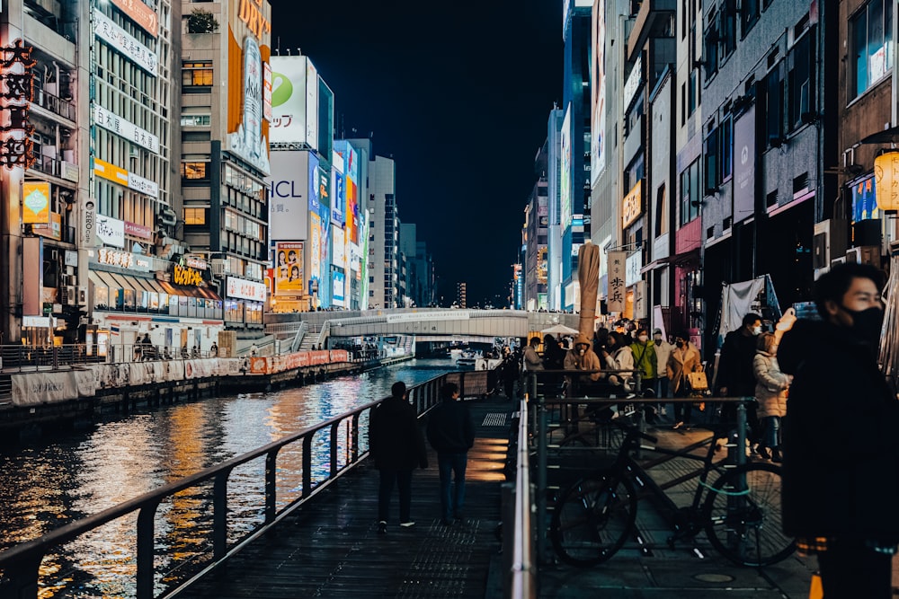 a group of people walking down a street next to a river