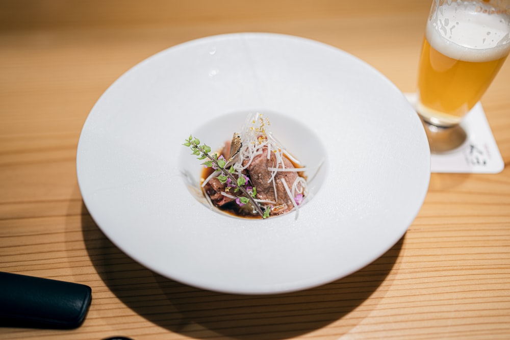 a white plate topped with food next to a glass of beer