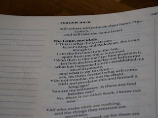 An open page of a book features text in a structured format, with headings and numbered lines. The text is focused and printed in a readable, serif font. The page number is visible at the top right corner.