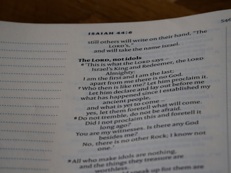 An open page of a book features text in a structured format, with headings and numbered lines. The text is focused and printed in a readable, serif font. The page number is visible at the top right corner.