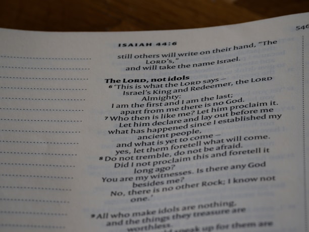 An open page of a book features text in a structured format, with headings and numbered lines. The text is focused and printed in a readable, serif font. The page number is visible at the top right corner.