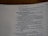 An open page of a book features text in a structured format, with headings and numbered lines. The text is focused and printed in a readable, serif font. The page number is visible at the top right corner.