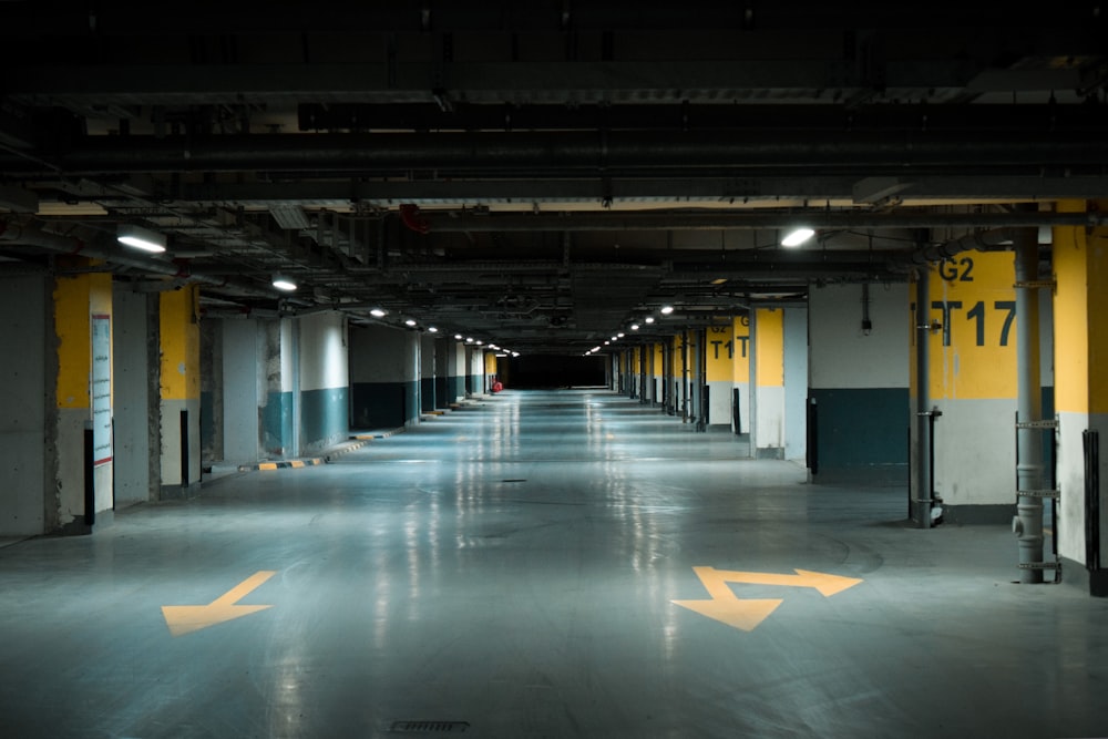 an empty parking garage with yellow arrows painted on the floor