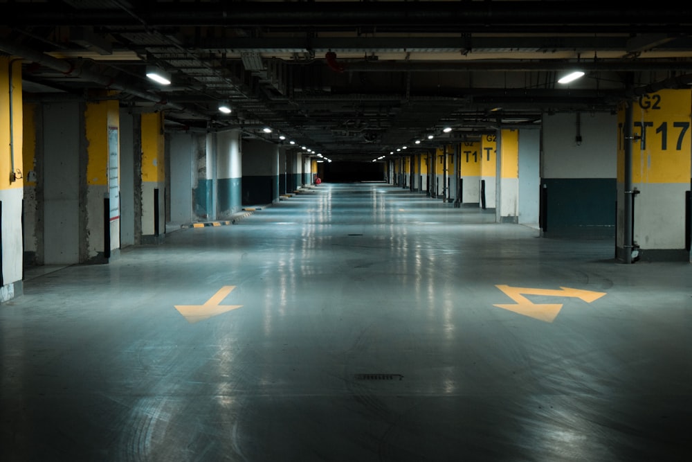 an empty parking garage with yellow arrows painted on the floor
