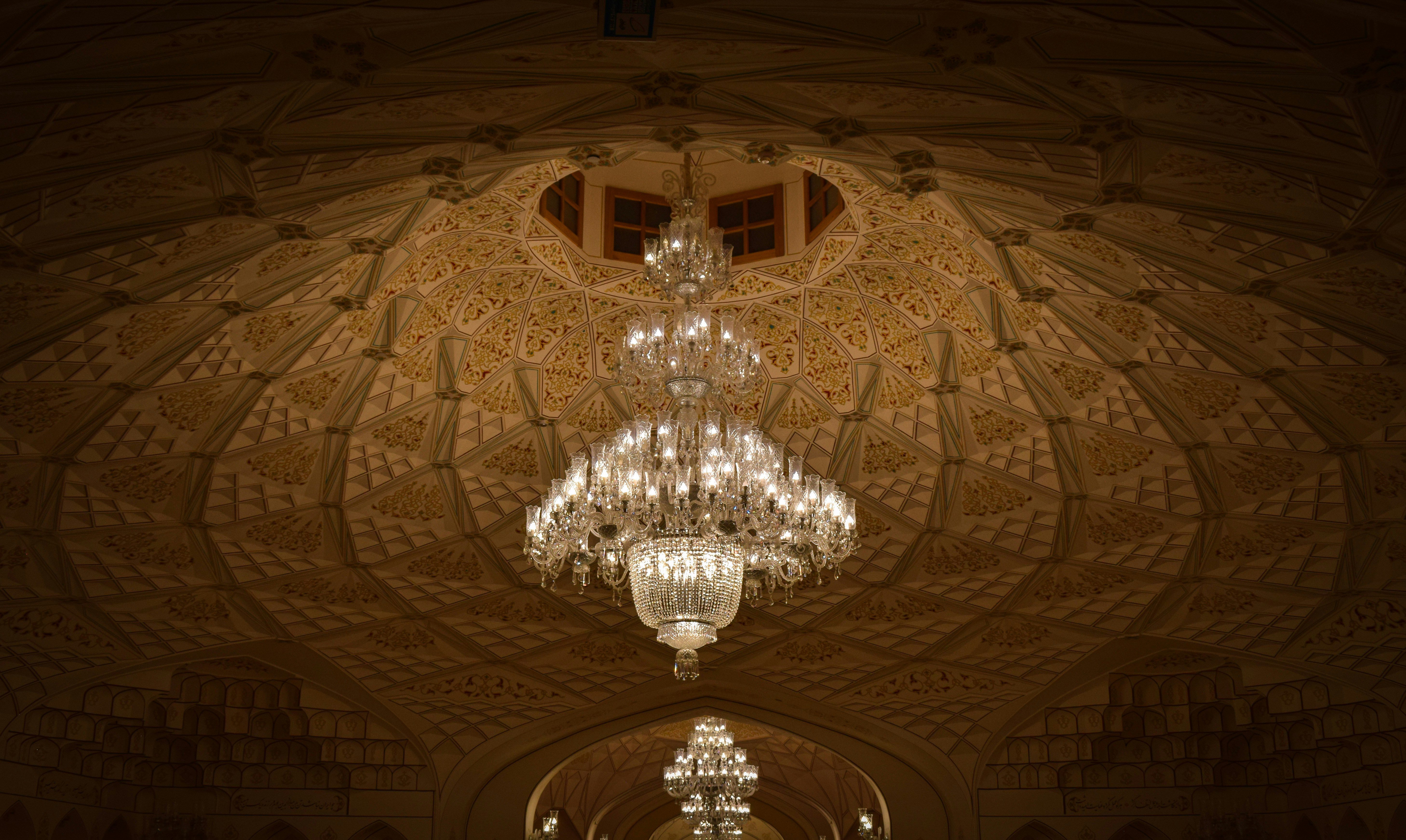 A chandelier hanging from the ceiling of a building photo Free Tehran Image on Unsplash