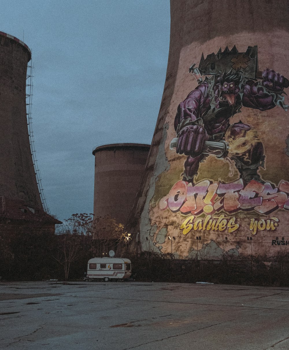 un'auto parcheggiata di fronte a un grande edificio con graffiti su di esso