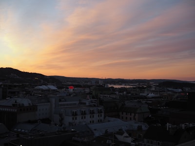 An expressive watercolor painting of a city street scene at dusk.