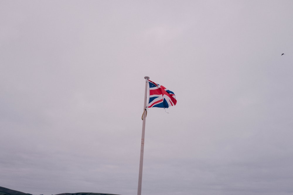 a british flag flying in the wind on a cloudy day