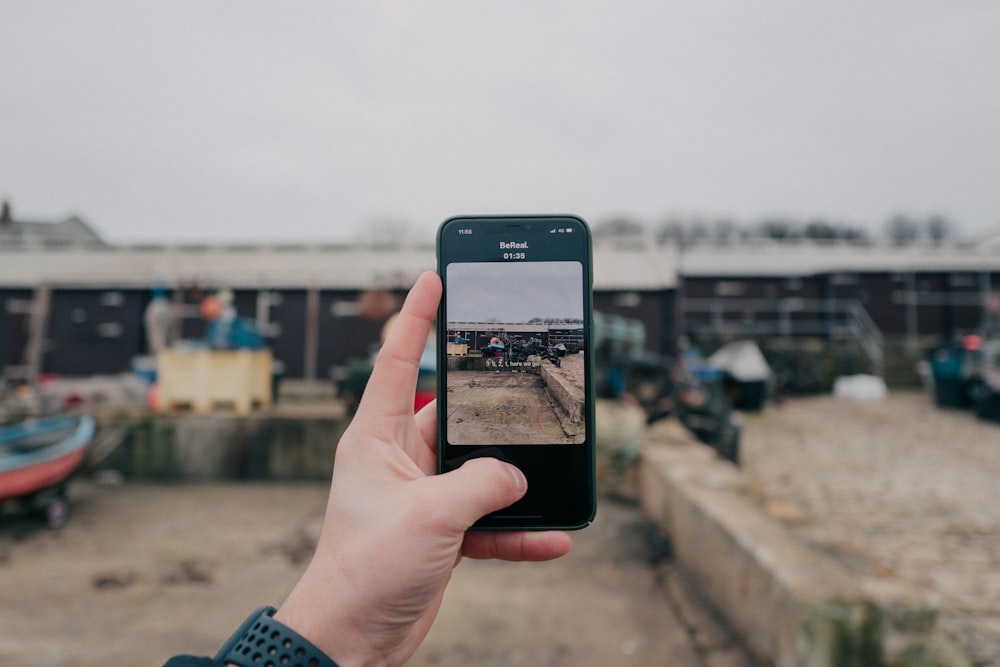 a person holding up a cell phone to take a picture