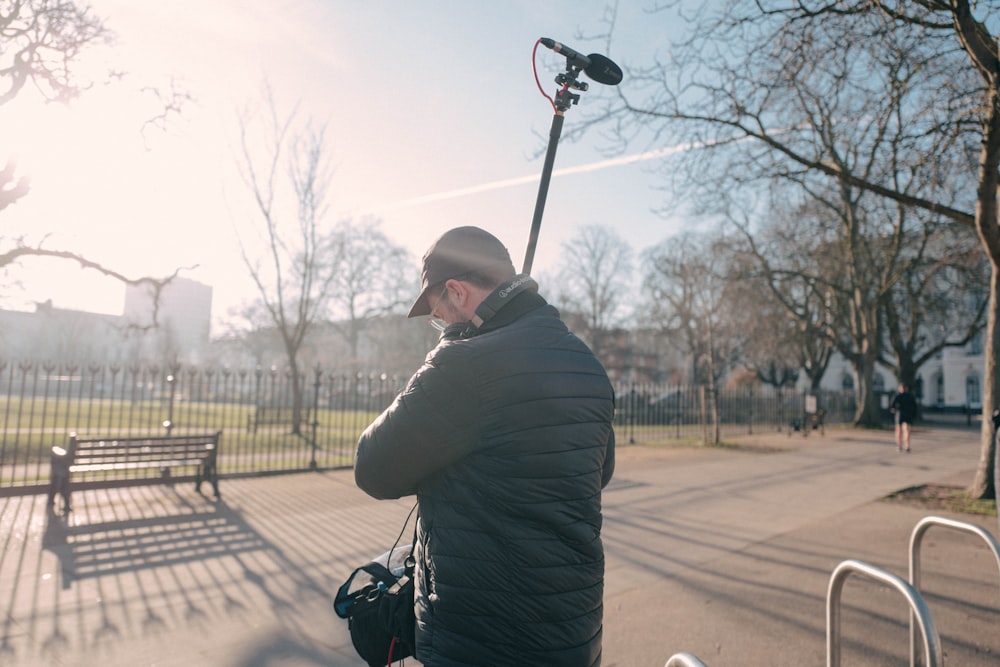 a man standing in front of a park bench