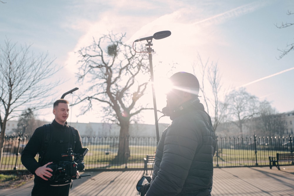 a man standing next to another man holding a camera