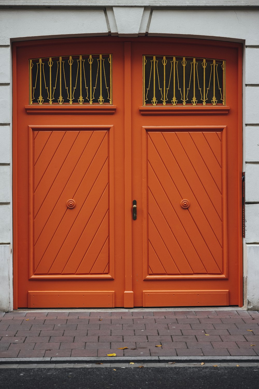 a couple of orange doors sitting on the side of a building