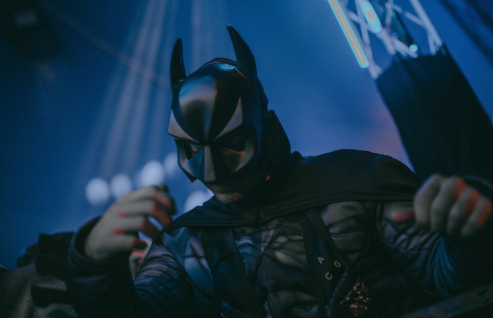 a man in a batman costume holding a cell phone