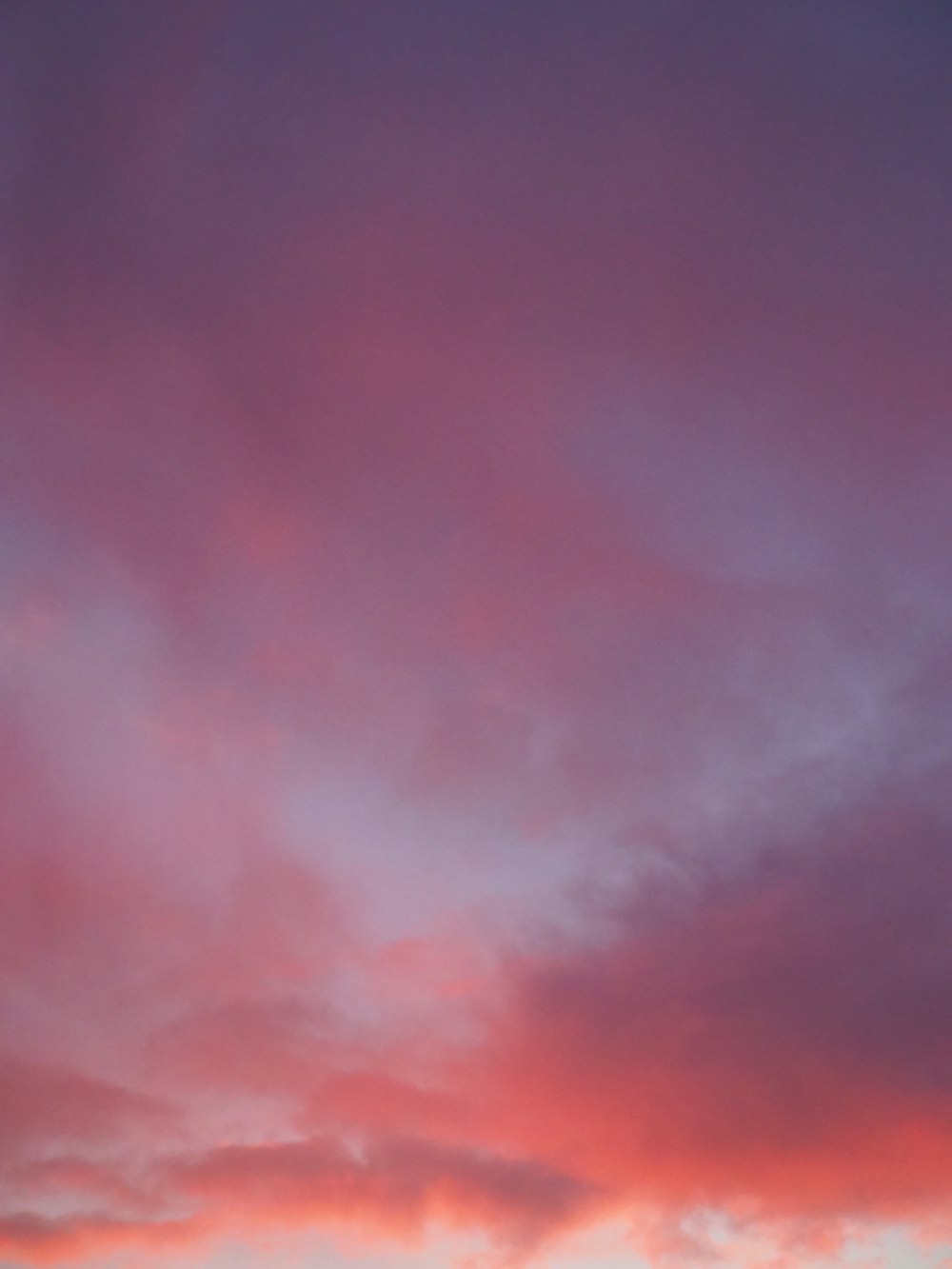 a plane flying in the sky at sunset