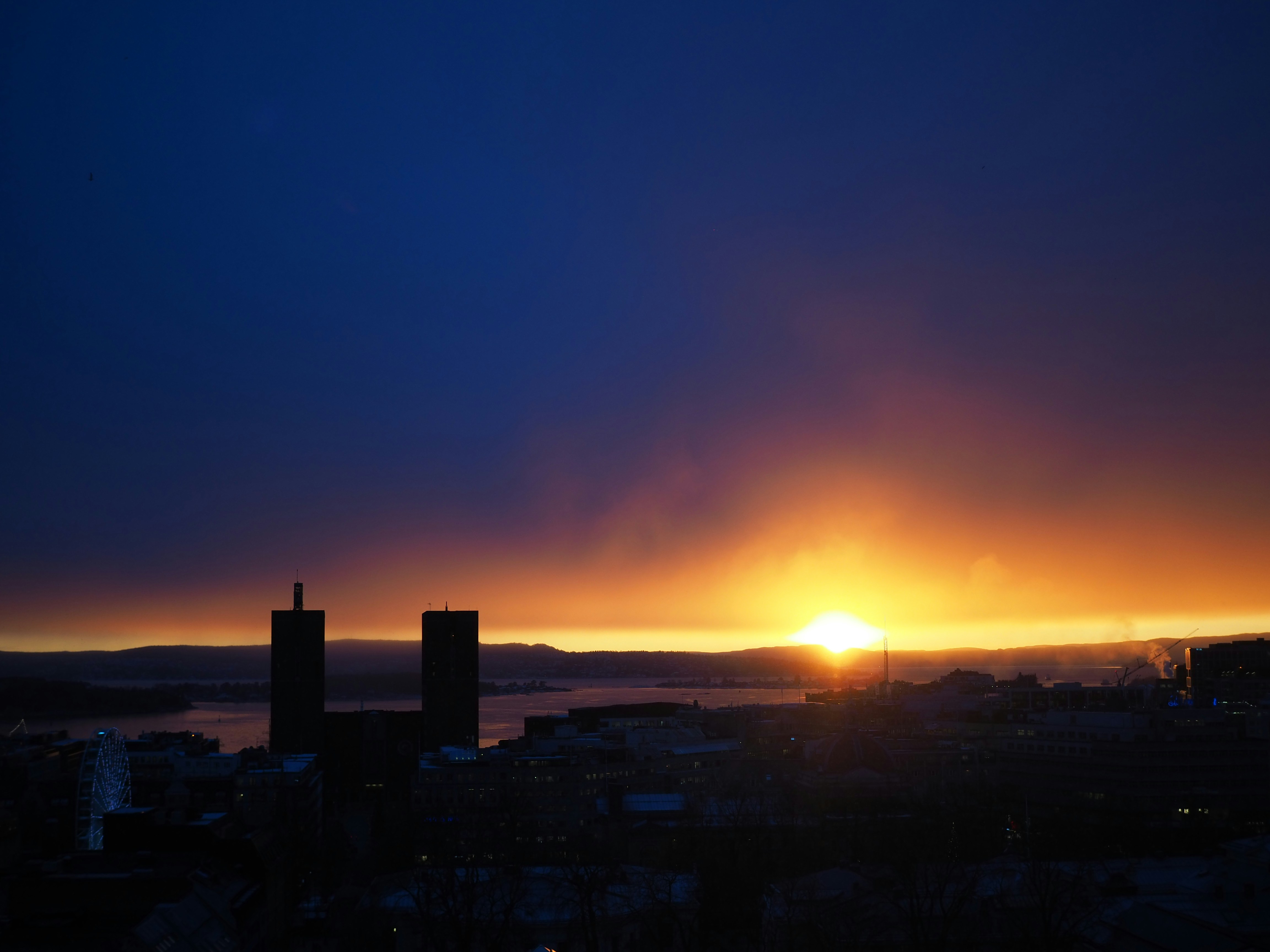 Il sole sta tramontando su una città con edifici alti