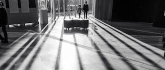 A professional agent guiding a couple through a sunlit luxury home with elegant interiors.