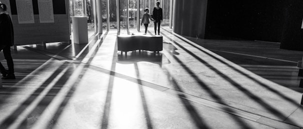 A professional agent guiding a couple through a sunlit luxury home with elegant interiors.