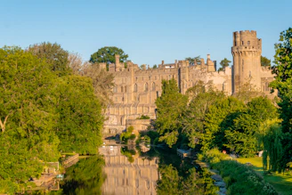 a castle is reflected in the water of a river