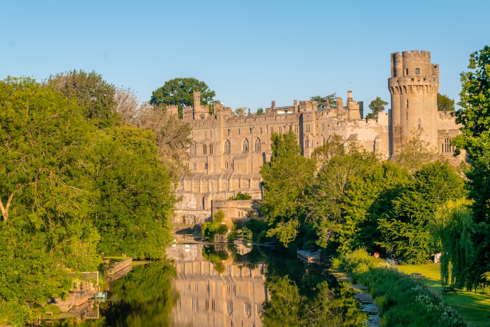 a castle is reflected in the water of a river