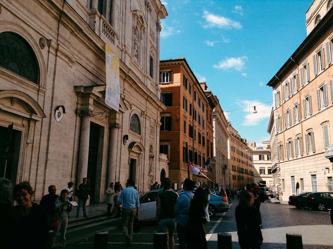 a group of people walking down a street next to tall buildings,