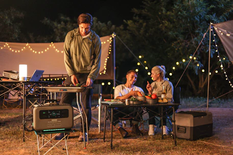 A family gathered around a campfire enjoying a meal made from custom freeze-dried recipes.