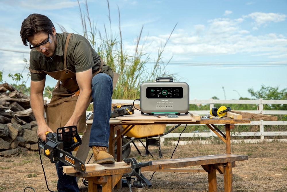 a man working on a table sawing a piece of wood