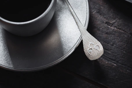 Close-up of a textured Japanese-style spoon resting on a sleek, matte-finish plate.