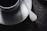 Close-up of a polished silver spoon resting on a rustic wooden table.