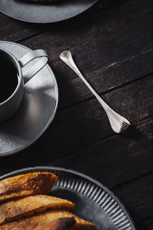 Close-up of a beautifully crafted brunch plate with artisanal coffee on a dark wooden table.