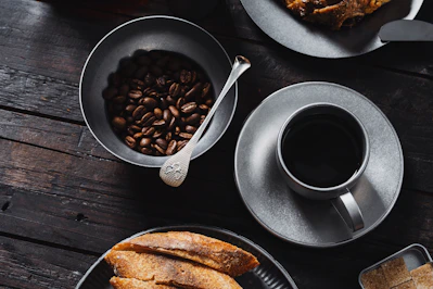 a table topped with plates of food and a cup of coffee