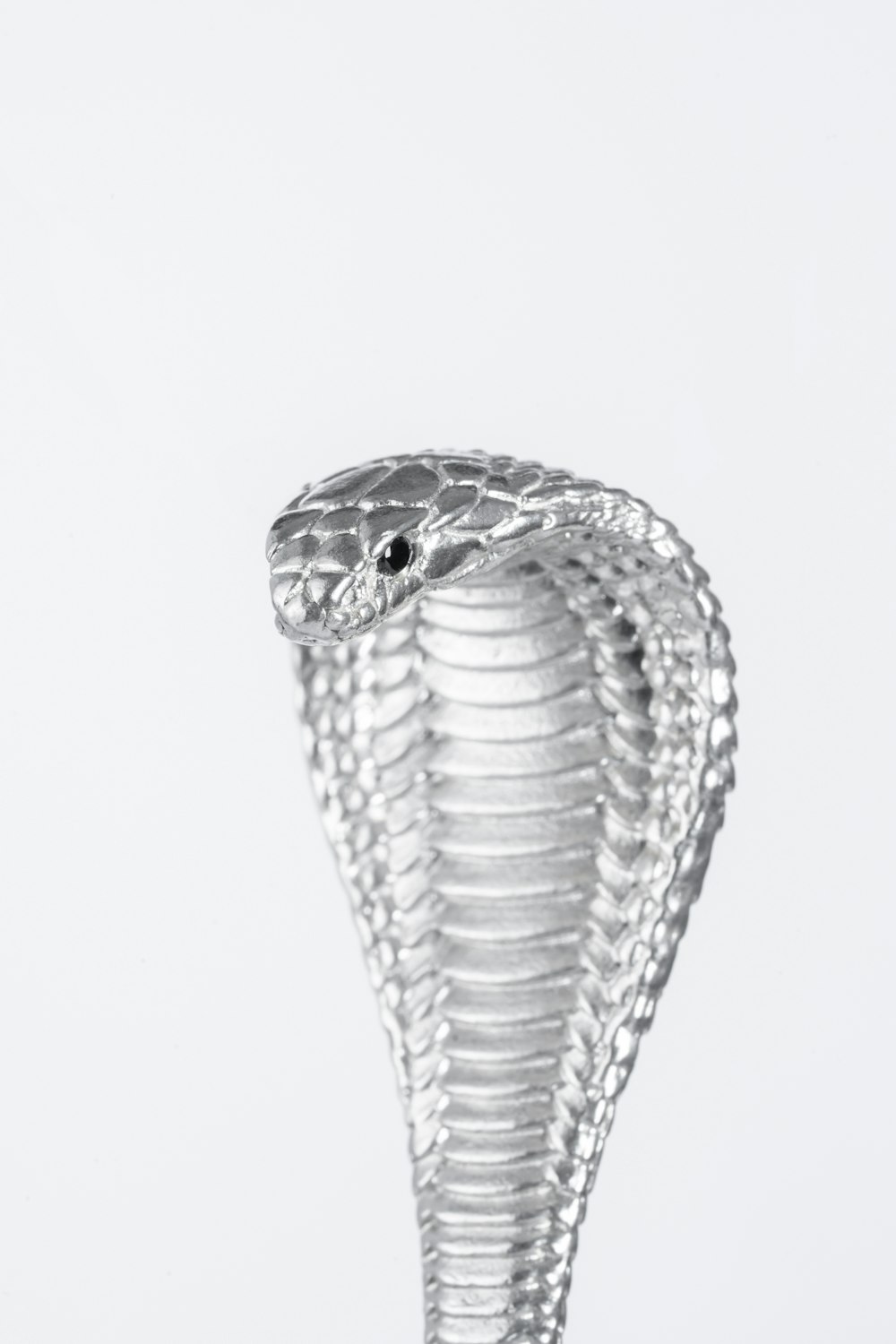 a silver snake statue on a white background