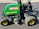 A green John Deere vehicle with a red MK5G68 label and a 3235C model designation parked on a paved surface. It features large black and yellow wheels and visible mechanical components, including hoses and metallic parts.