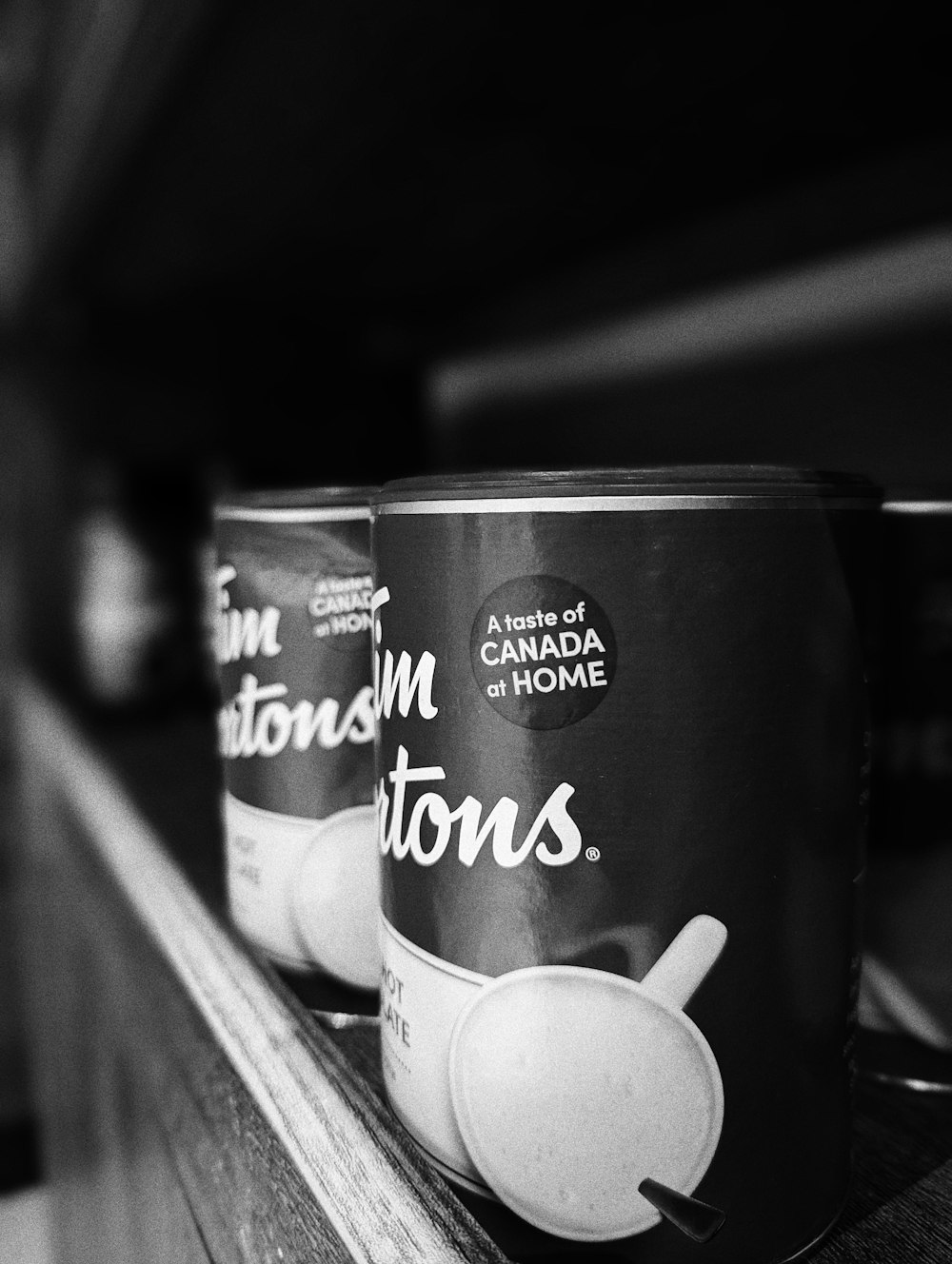 two cups of ice cream sitting on top of a wooden shelf