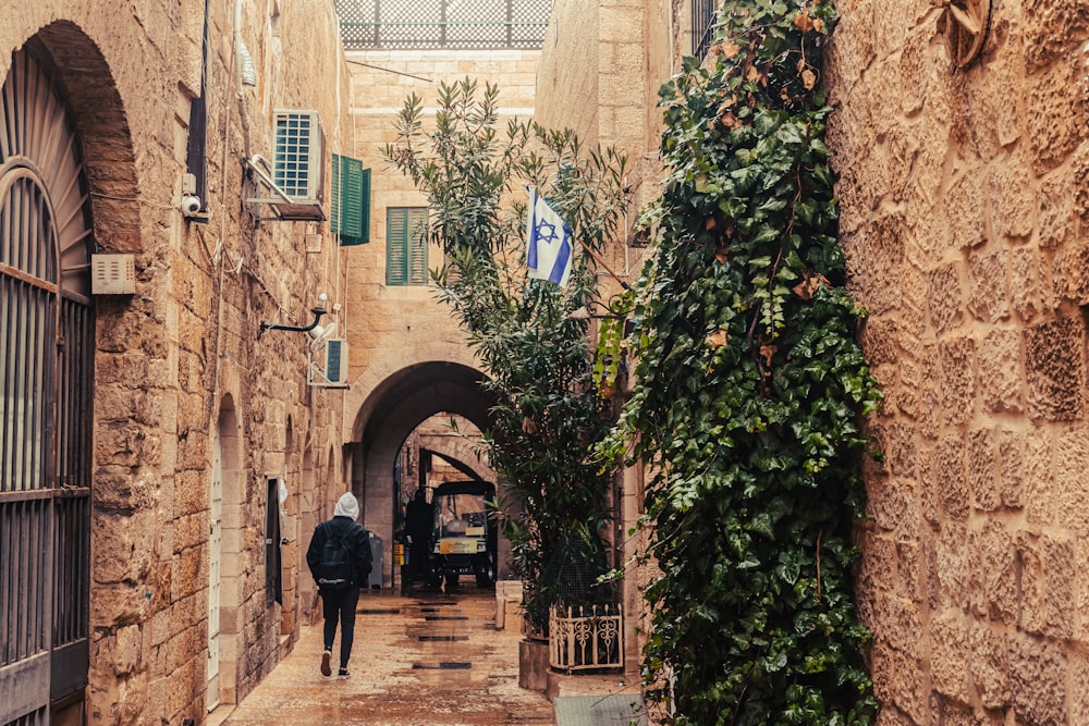 a man walking down a narrow alley way