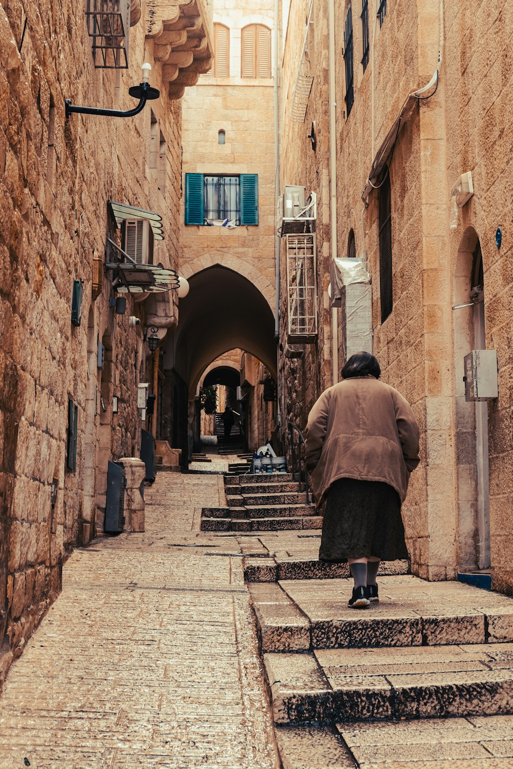 a man walking down a narrow alley way