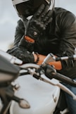 a man in a leather jacket and helmet on a motorcycle
