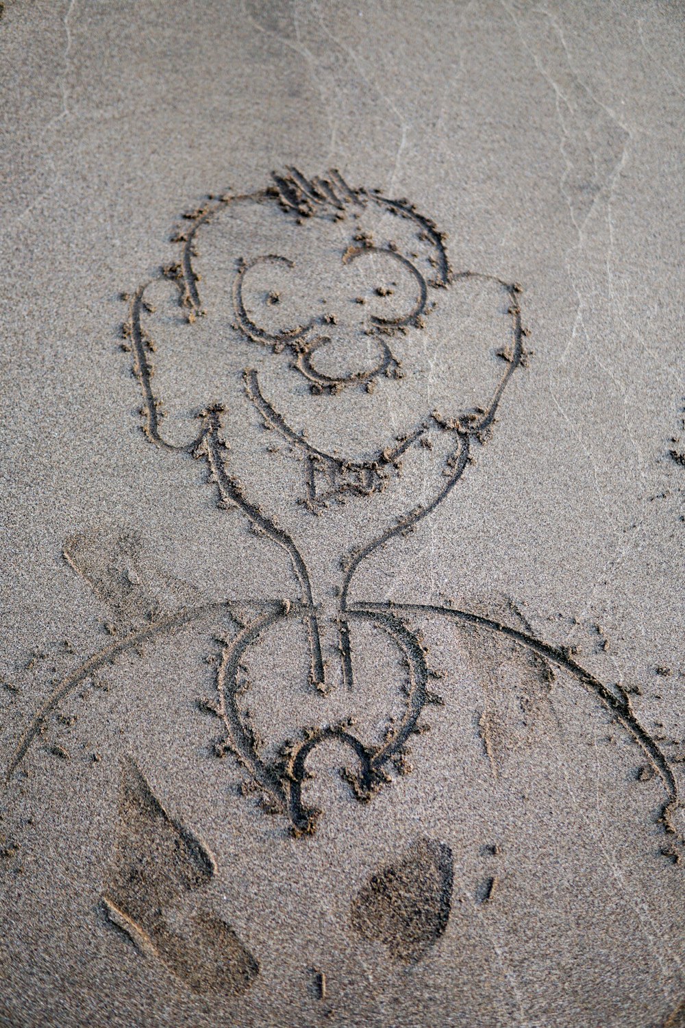 a child's face is drawn in the sand