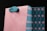 A stylish shopping bag with a salmon pink exterior and a teal handle. The interior features a geometric pattern in teal and pink with star-like shapes. The bag appears to be made of sturdy paper or cardboard.