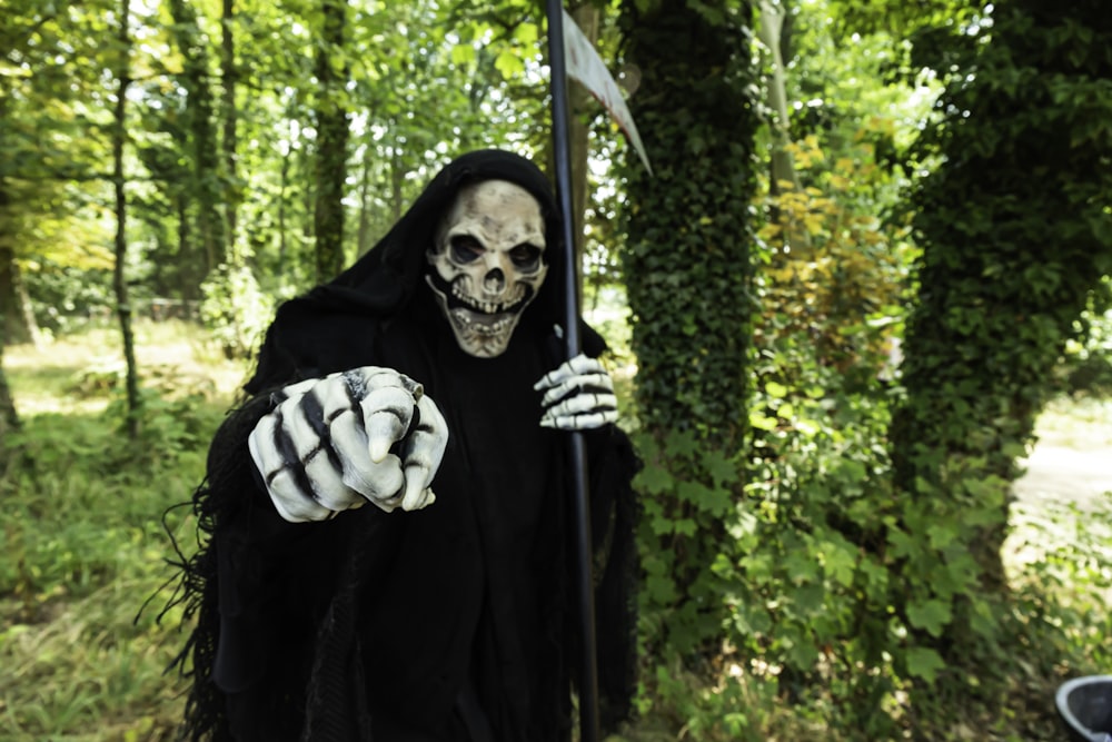 a skeleton holding a flag in a forest