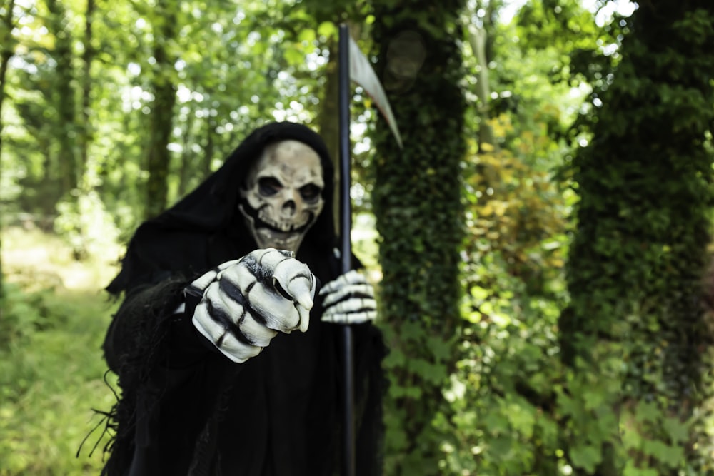 a skeleton holding a flag in a forest