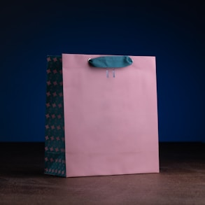 a pink shopping bag with a blue handle