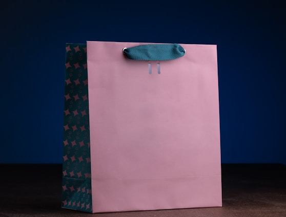 a pink shopping bag with a blue handle