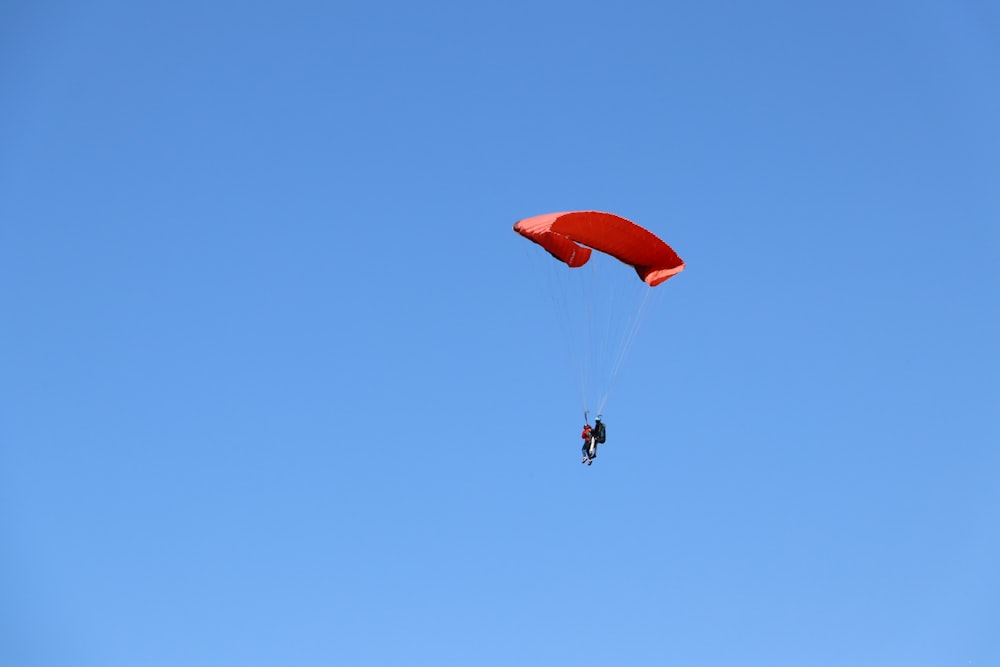 a person is parasailing against a blue sky