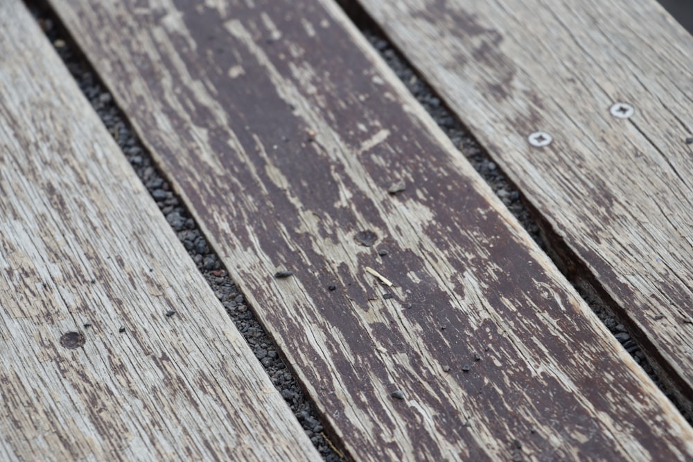 a close up of a wooden bench with nails on it