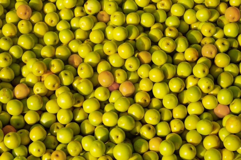 a large pile of green apples sitting on top of each other