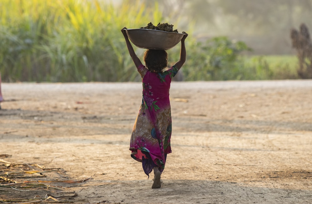 a woman carrying a bowl on her head